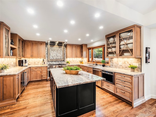 62 N Ranch Rd, Littleton, CO 80127 - kitchen with appliances with stainless steel finishes, a sink, a kitchen island, light wood finished floors, and light stone countertops