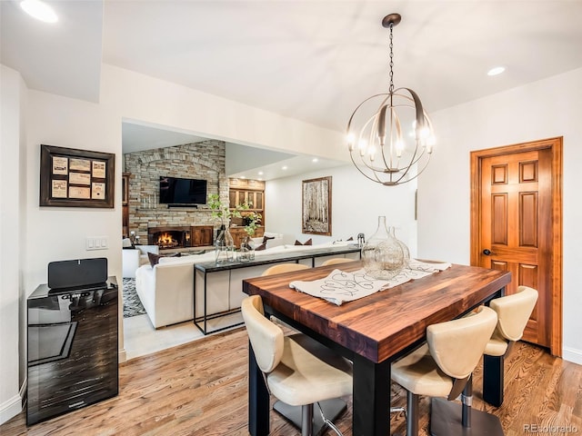 62 N Ranch Rd, Littleton, CO 80127 - dining area featuring light wood-style floors, a chandelier, a fireplace, baseboards, and recessed lighting