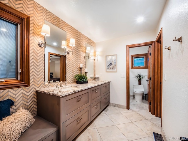 62 N Ranch Rd, Littleton, CO 80127 - full bath with double vanity, toilet, tile patterned floors, and baseboards