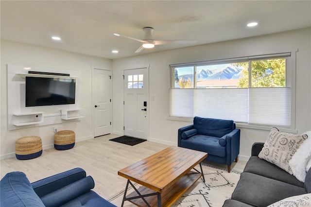 living room with plenty of natural light, light hardwood / wood-style flooring, and ceiling fan