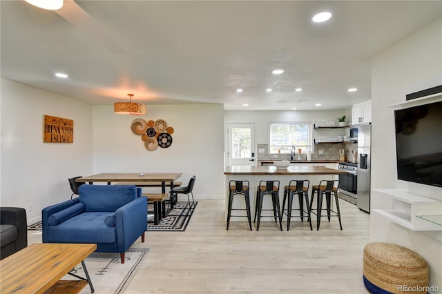 dining area featuring light wood-type flooring and sink