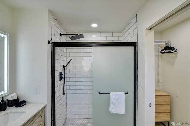 bathroom with a shower with shower door and vanity