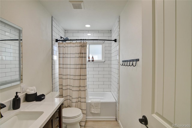 full bathroom with vanity, shower / bath combo with shower curtain, and toilet