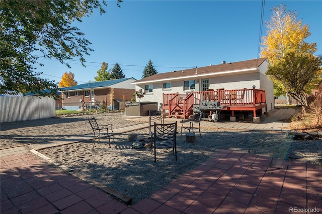 rear view of house with a wooden deck and a patio area