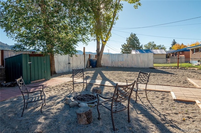 view of yard featuring a fire pit and a storage shed