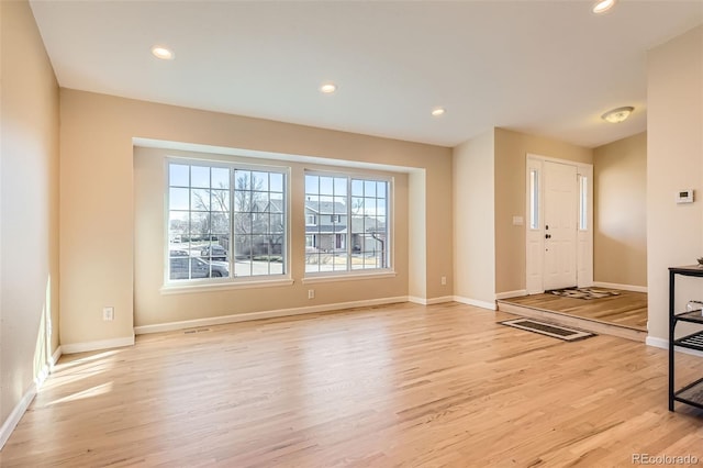 foyer featuring baseboards, light wood finished floors, visible vents, and recessed lighting