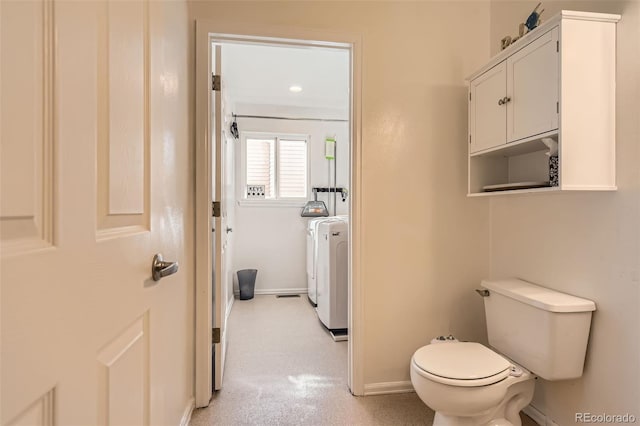 bathroom with washer / clothes dryer, toilet, and baseboards