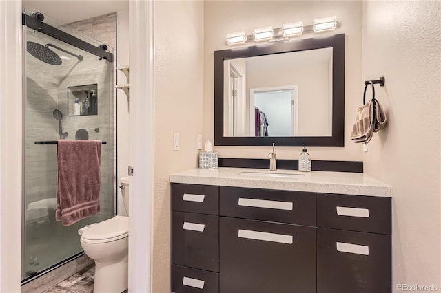 full bath with toilet, a shower stall, wood finished floors, and vanity