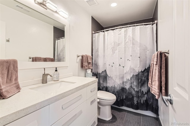 bathroom featuring visible vents, vanity, toilet, and tile patterned floors