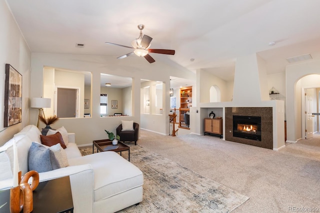 living room featuring ceiling fan, vaulted ceiling, light carpet, and a fireplace