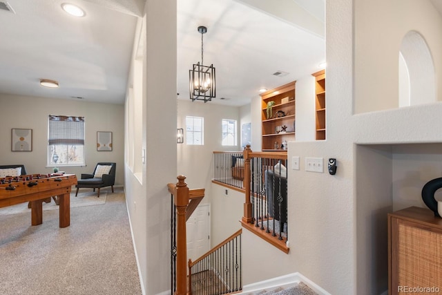 interior space featuring an inviting chandelier, carpet flooring, and built in features