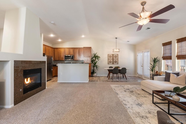 carpeted living room featuring ceiling fan, a fireplace, and lofted ceiling