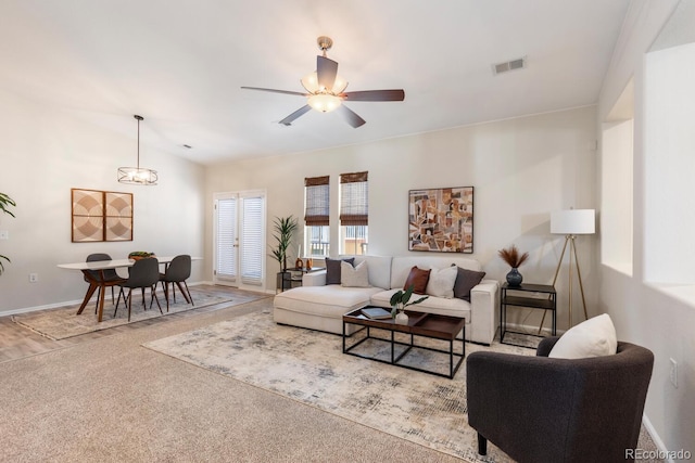 carpeted living room with ceiling fan