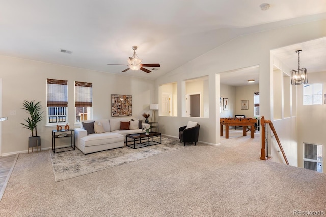 living room with vaulted ceiling, carpet, and ceiling fan with notable chandelier