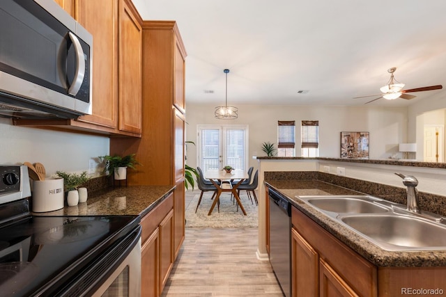 kitchen with light hardwood / wood-style floors, ceiling fan, stainless steel appliances, pendant lighting, and sink