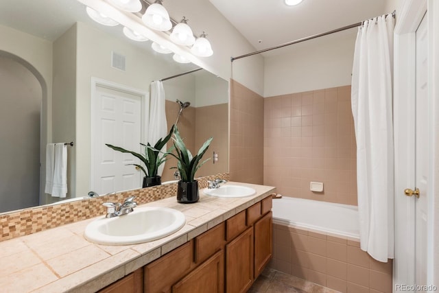 bathroom featuring vanity and shower / bathtub combination with curtain