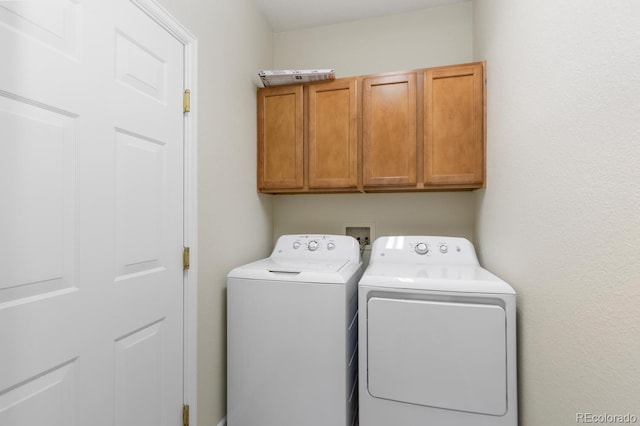 washroom with washing machine and dryer and cabinets