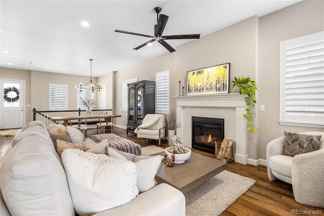 living room with dark hardwood / wood-style floors and ceiling fan with notable chandelier