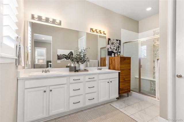 bathroom featuring a shower with door and vanity