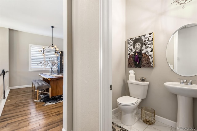 bathroom featuring sink, toilet, a chandelier, and hardwood / wood-style floors