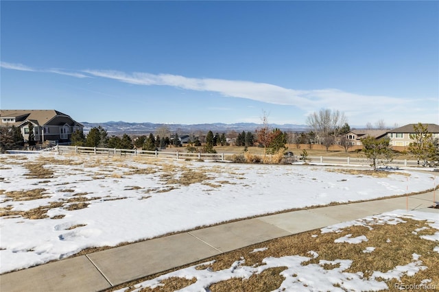 yard covered in snow featuring a mountain view