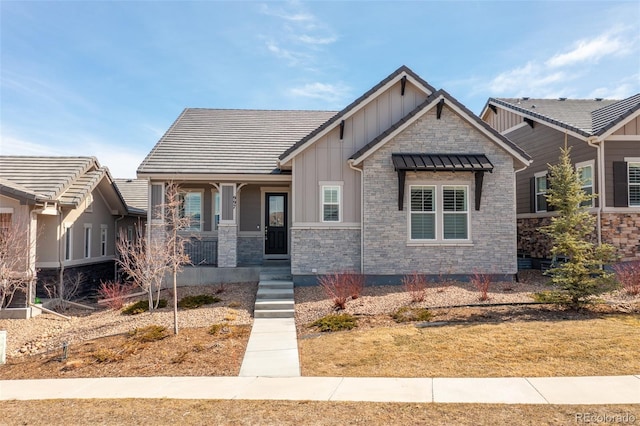 craftsman-style house with a porch, board and batten siding, and stone siding
