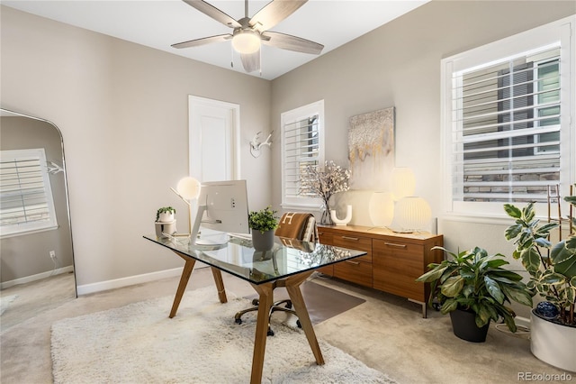 office area with light carpet, baseboards, and a ceiling fan