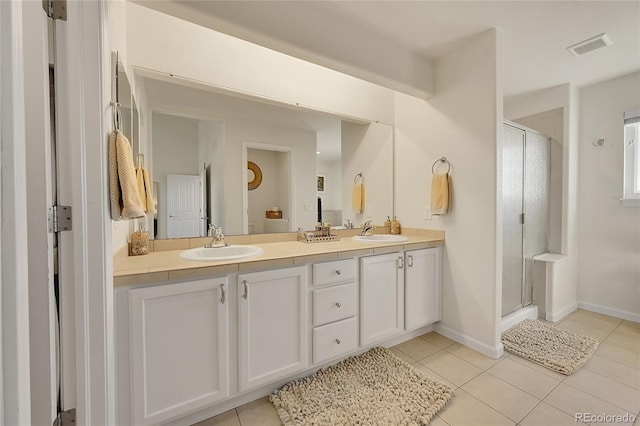 full bath with tile patterned floors, a shower stall, and a sink