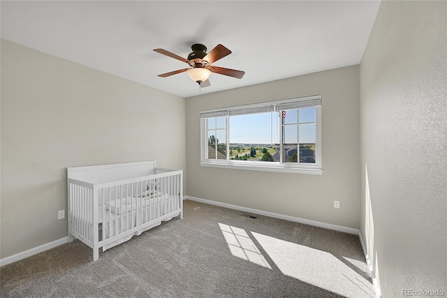 unfurnished bedroom with visible vents, baseboards, a ceiling fan, and carpet flooring