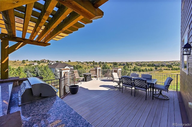 wooden terrace with area for grilling, outdoor dining space, and a grill