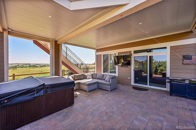 view of patio / terrace with an outdoor hangout area, a hot tub, and stairs