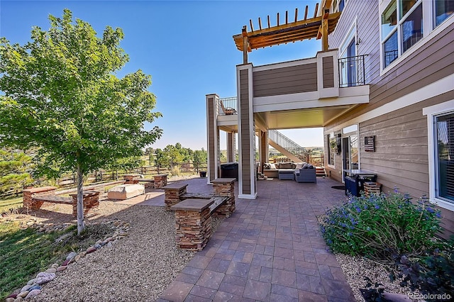 view of patio with stairway, outdoor lounge area, and a balcony