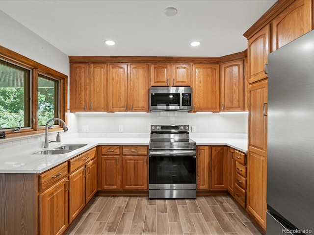 1827 S Fairfax St, Denver, CO 80222 - kitchen with stainless steel appliances, brown cabinetry, light countertops, light wood finished floors, and recessed lighting