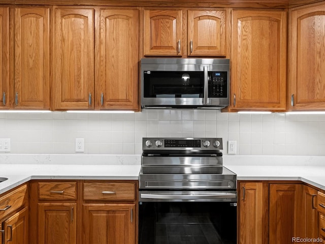 1827 S Fairfax St, Denver, CO 80222 - kitchen featuring appliances with stainless steel finishes, backsplash, light countertops, and brown cabinets