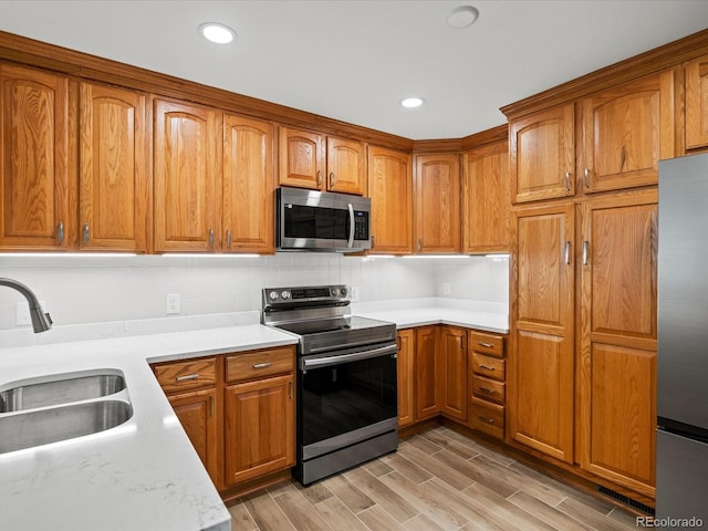 1827 S Fairfax St, Denver, CO 80222 - kitchen featuring appliances with stainless steel finishes, light countertops, brown cabinetry, and recessed lighting