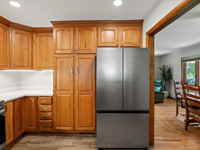1827 S Fairfax St, Denver, CO 80222 - kitchen featuring freestanding refrigerator, recessed lighting, brown cabinets, light wood finished floors, and light countertops