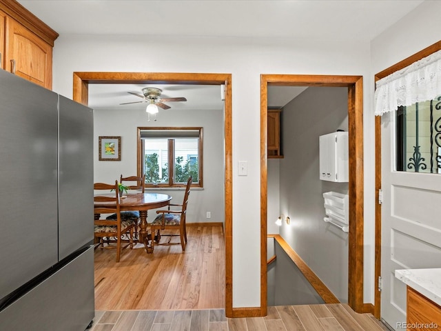 1827 S Fairfax St, Denver, CO 80222 - kitchen with freestanding refrigerator, a ceiling fan, light wood finished floors, and brown cabinets