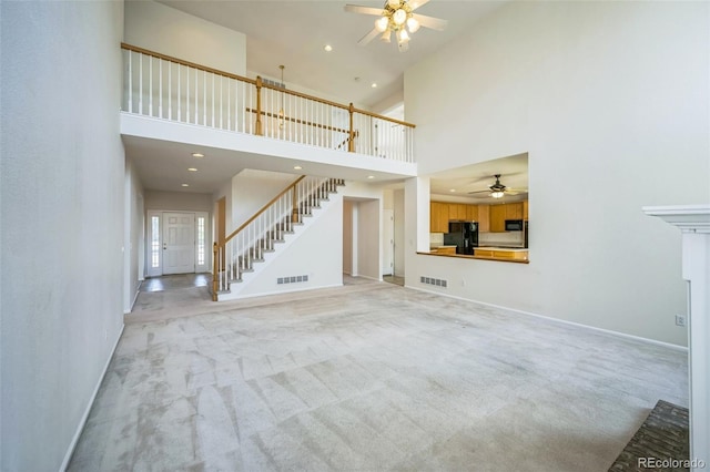19076 E Lasalle Pl, Aurora, CO 80013 - unfurnished living room with a ceiling fan, stairway, light colored carpet, a high ceiling, and recessed lighting