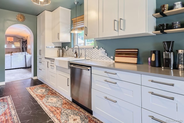 6995 W 27th Ave, Wheat Ridge, CO 80033 - kitchen featuring stainless steel dishwasher, white cabinetry, tasteful backsplash, arched walkways, and light countertops