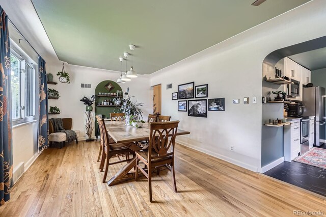 6995 W 27th Ave, Wheat Ridge, CO 80033 - dining area featuring light wood-style floors and arched walkways
