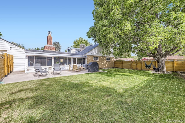 6995 W 27th Ave, Wheat Ridge, CO 80033 - rear view of house featuring a chimney, a sunroom, a fenced backyard, and a patio