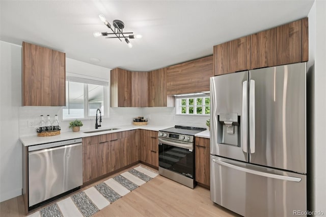 169 Yates St, Denver, CO 80219 - kitchen featuring stainless steel appliances, light countertops, brown cabinets, and modern cabinets