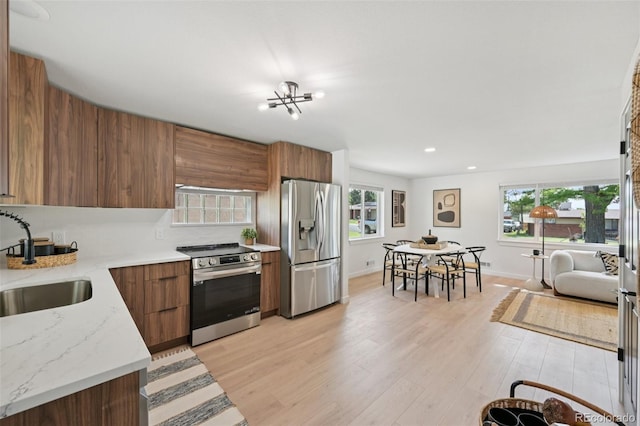 169 Yates St, Denver, CO 80219 - kitchen with stainless steel appliances, modern cabinets, brown cabinetry, light wood finished floors, and recessed lighting