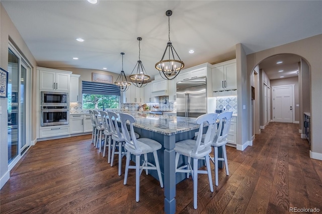 31455 Half Peak Trl, Pine, CO 80470 - dining room with arched walkways, a chandelier, recessed lighting, dark wood finished floors, and baseboards