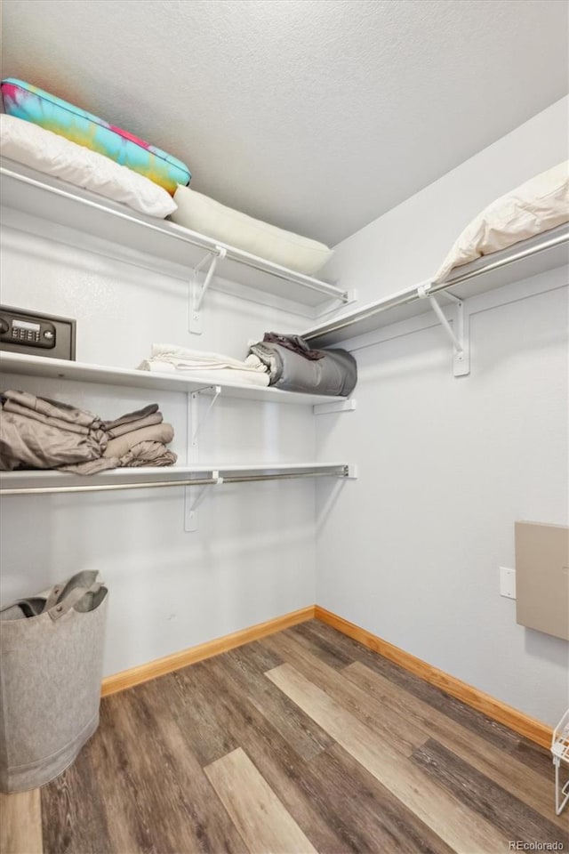 walk in closet with wood finished floors