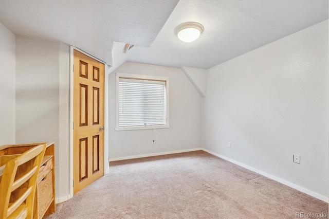 additional living space featuring carpet flooring, lofted ceiling, and baseboards