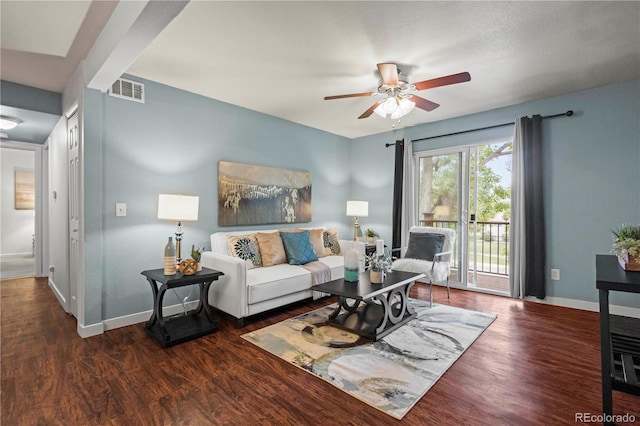 living room with ceiling fan and dark wood-type flooring