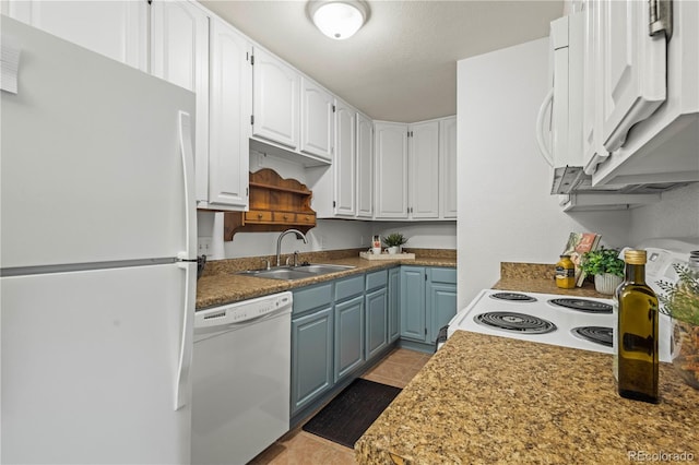 kitchen with light tile patterned floors, sink, white appliances, white cabinetry, and blue cabinetry