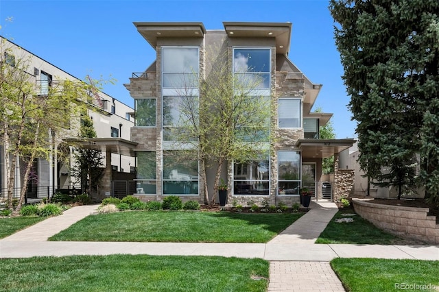 view of front of house with a front yard and stone siding