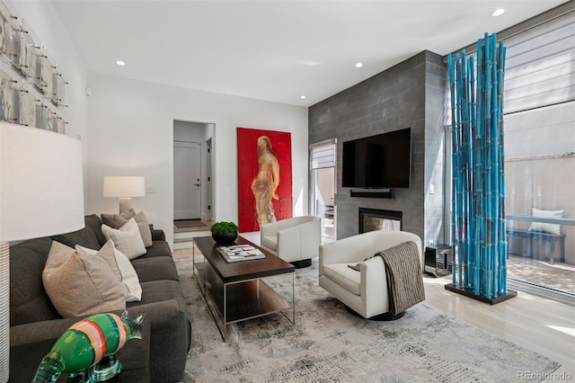 living room with recessed lighting, wood finished floors, and a fireplace